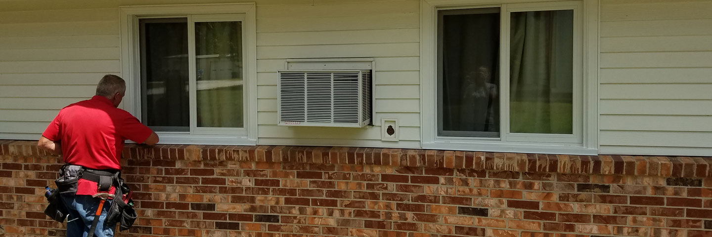 carpenter works on window and siding at a residential home Seamless Experts residential and commercial exterior remodeling Ozarks Missouri